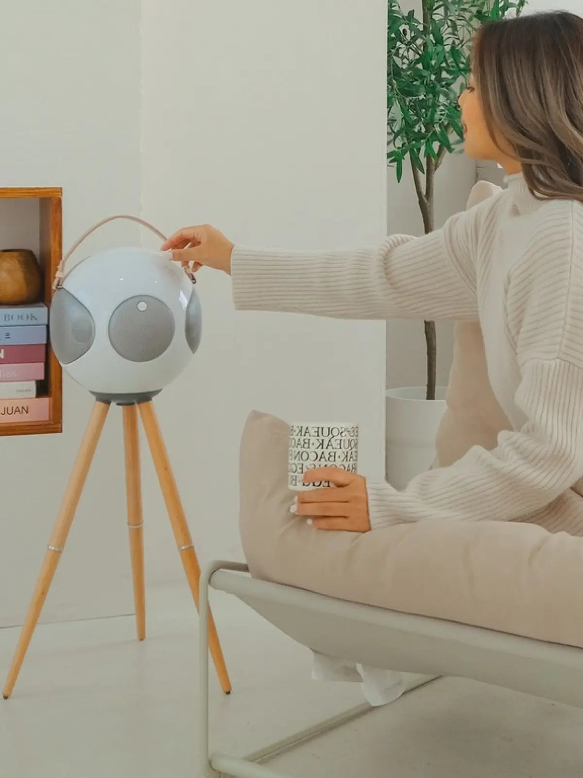 S2+ ALPHORN Bluetooth circle speaker in home setting in white. Attached to the tripod